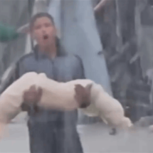 فتى فلسطيني يحمل جثة صغيرة وسط السيول في غزة (فيديو)